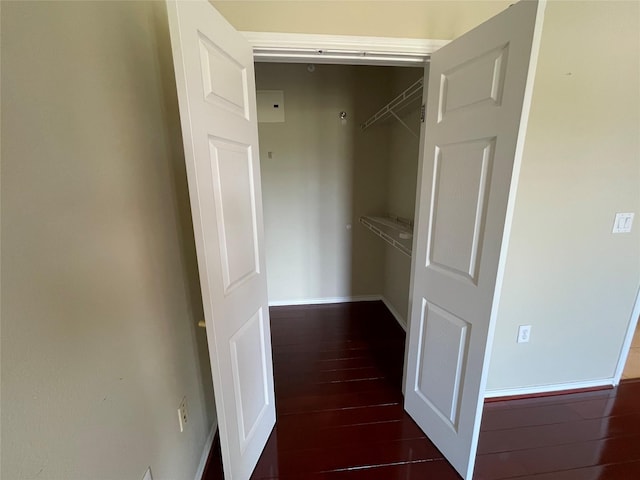 walk in closet with dark hardwood / wood-style floors