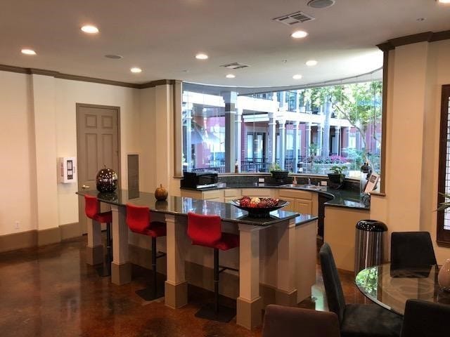 bar featuring sink, expansive windows, and ornamental molding