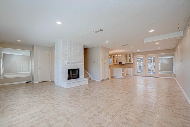 unfurnished living room with a fireplace and french doors