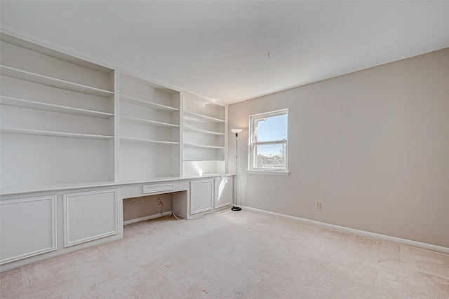 unfurnished office featuring light carpet and built in desk