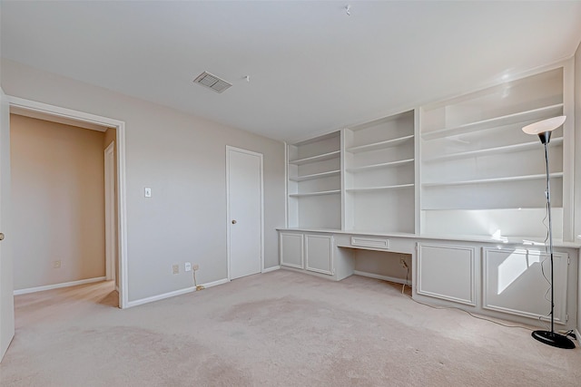 unfurnished office featuring light carpet and built in desk