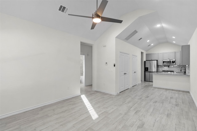 unfurnished living room with ceiling fan, lofted ceiling, and light hardwood / wood-style flooring