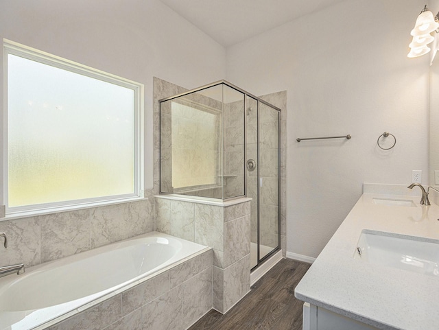 bathroom with hardwood / wood-style flooring, vanity, and shower with separate bathtub