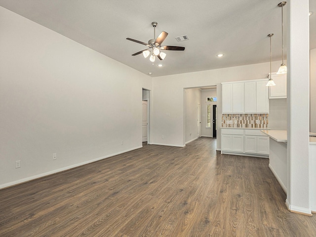 unfurnished living room with ceiling fan and dark wood-type flooring