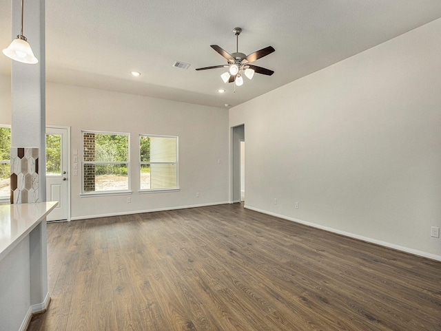 unfurnished living room featuring dark hardwood / wood-style flooring and ceiling fan