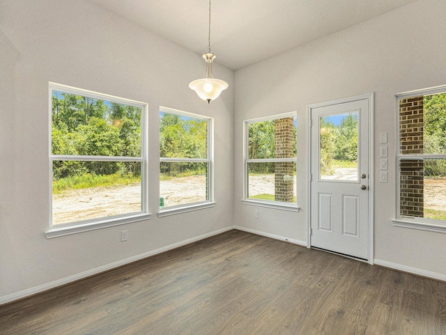 unfurnished dining area featuring dark hardwood / wood-style flooring and vaulted ceiling