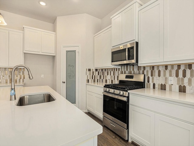 kitchen with backsplash, white cabinetry, sink, and stainless steel appliances