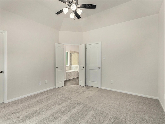 unfurnished bedroom with ceiling fan, light colored carpet, and ensuite bath