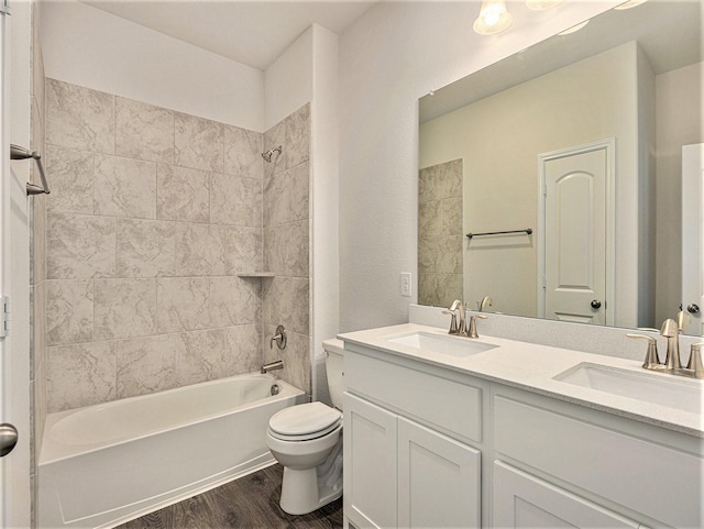 full bathroom featuring hardwood / wood-style floors, vanity, toilet, and tiled shower / bath