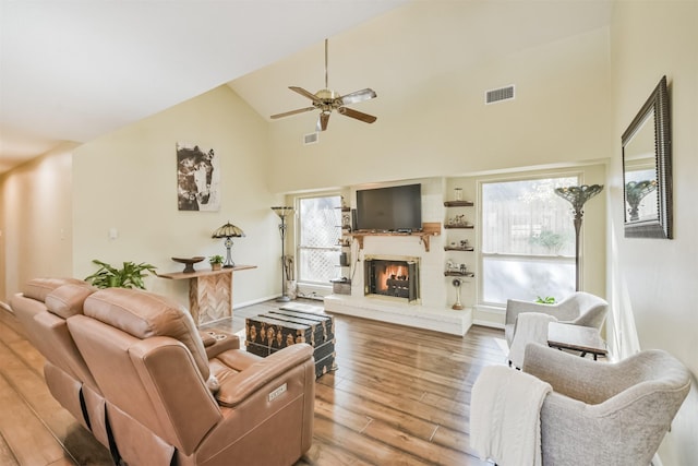 living room with ceiling fan, a fireplace, and a wealth of natural light