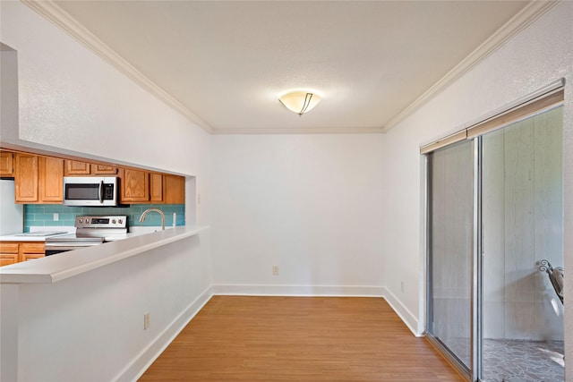 kitchen featuring stainless steel appliances, tasteful backsplash, crown molding, and light hardwood / wood-style floors