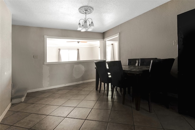 tiled dining space featuring a textured ceiling and a notable chandelier