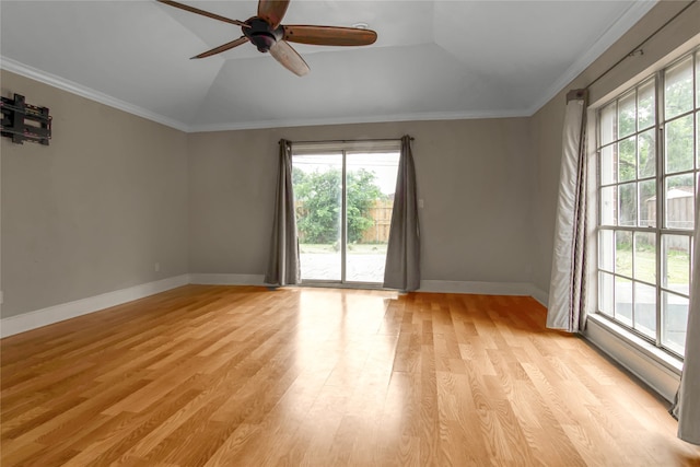 empty room featuring ceiling fan, crown molding, light hardwood / wood-style floors, lofted ceiling, and a tray ceiling