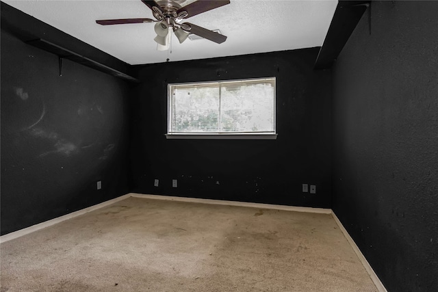 carpeted empty room featuring ceiling fan and a textured ceiling