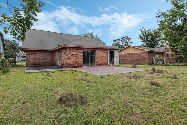 back of house featuring a lawn and a patio