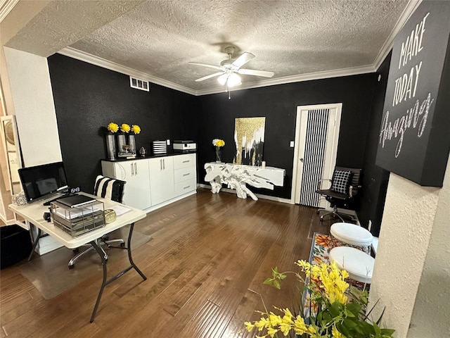 office space with a textured ceiling, dark hardwood / wood-style flooring, ceiling fan, and crown molding