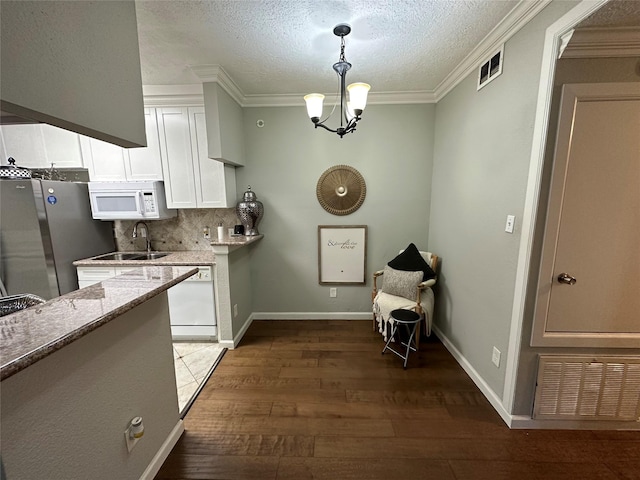 kitchen with decorative backsplash, light stone counters, white appliances, decorative light fixtures, and white cabinets