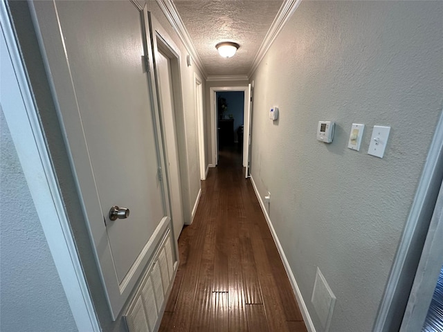 hall with a textured ceiling, dark hardwood / wood-style floors, and crown molding