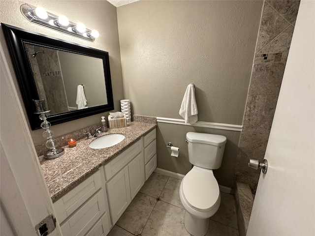 bathroom with tile patterned flooring, vanity, and toilet