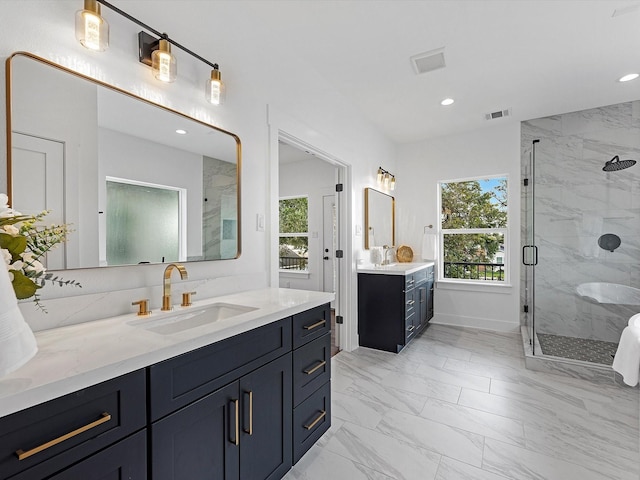 bathroom featuring a wealth of natural light, vanity, and walk in shower