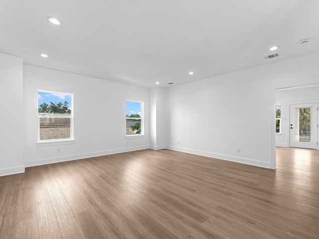 empty room with plenty of natural light and dark hardwood / wood-style floors