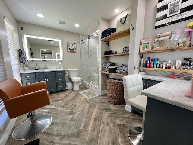 bathroom featuring vanity, a shower with door, toilet, parquet flooring, and a textured ceiling