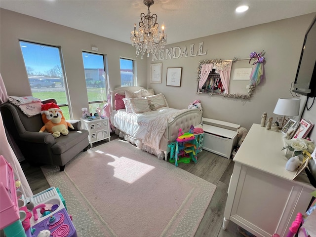 bedroom with dark hardwood / wood-style floors and an inviting chandelier