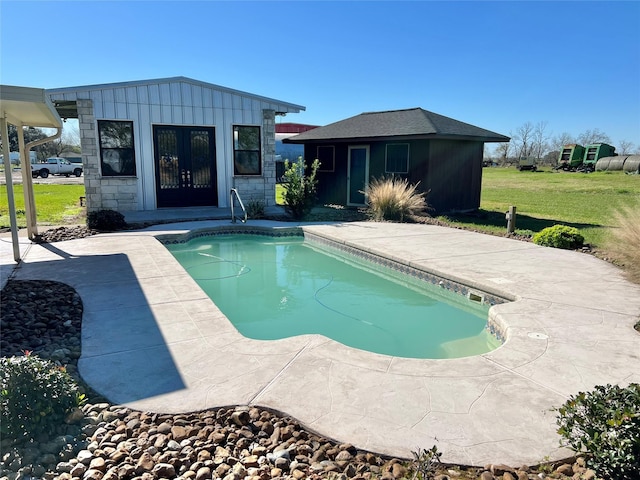 view of pool featuring an outbuilding, a yard, and a patio