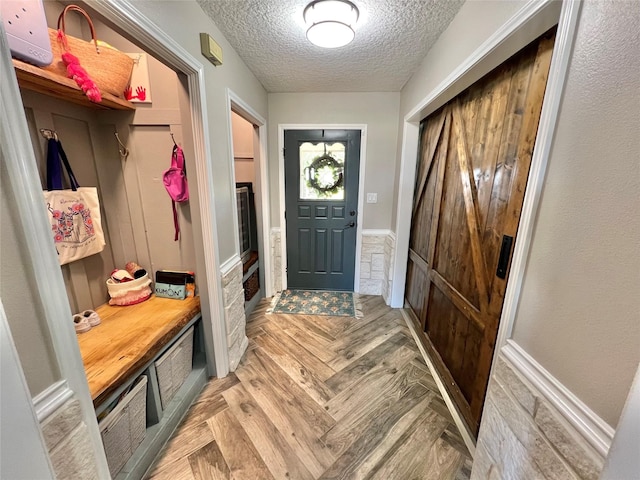 mudroom with light parquet floors and a textured ceiling