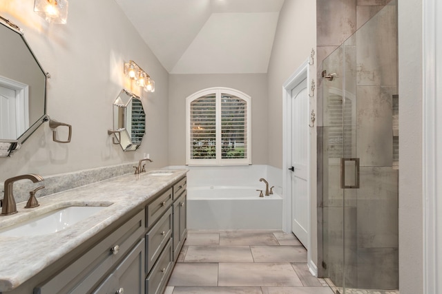 bathroom with vanity, independent shower and bath, and vaulted ceiling