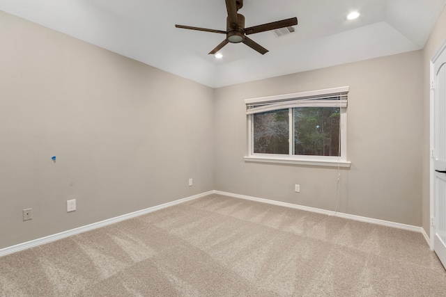 carpeted empty room featuring ceiling fan and a raised ceiling