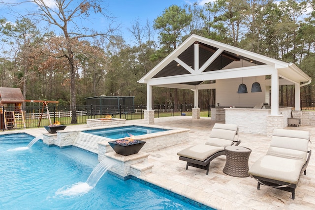 view of swimming pool with an in ground hot tub, exterior bar, pool water feature, a gazebo, and a playground