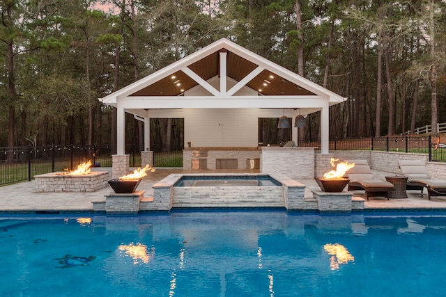 view of swimming pool featuring a gazebo, a patio area, an in ground hot tub, and an outdoor fire pit