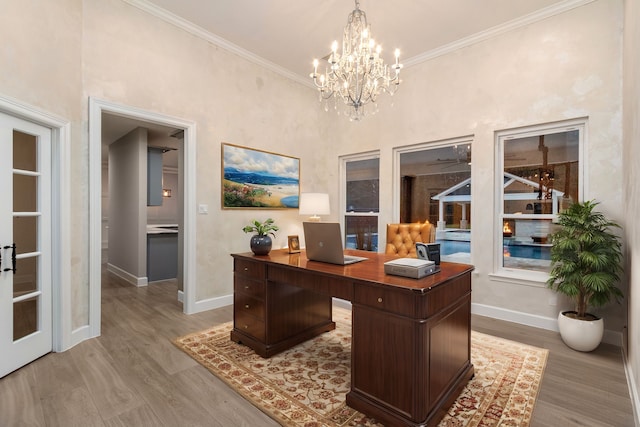 office featuring a notable chandelier, light wood-type flooring, and crown molding