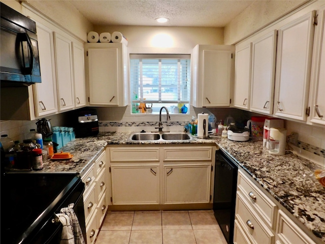 kitchen featuring light stone counters, black appliances, tasteful backsplash, light tile patterned flooring, and sink