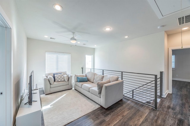 living room featuring ceiling fan and dark wood-type flooring