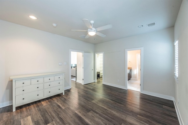 unfurnished bedroom featuring connected bathroom, dark hardwood / wood-style floors, and ceiling fan