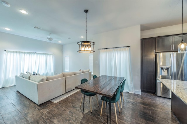 dining room with ceiling fan with notable chandelier