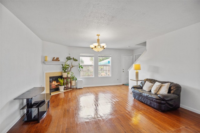 sitting room with hardwood / wood-style flooring, a fireplace, and an inviting chandelier