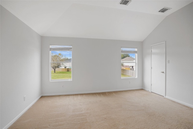 carpeted empty room with lofted ceiling