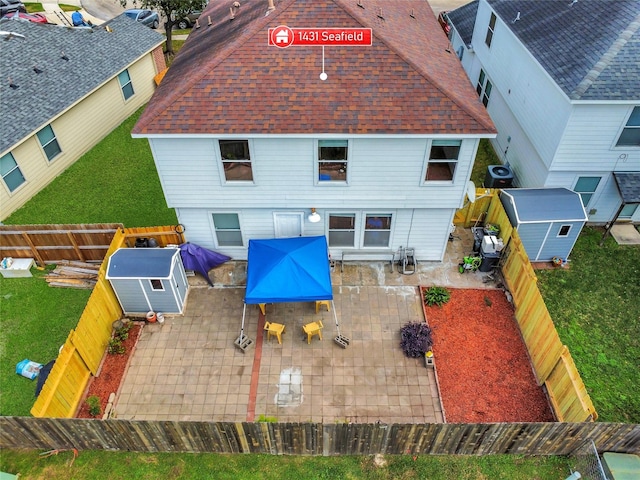 rear view of house with a shed, central air condition unit, and a patio