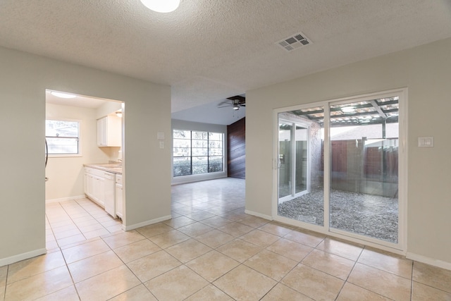 tiled spare room featuring ceiling fan, sink, and a textured ceiling