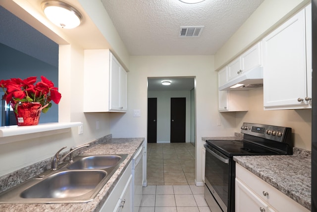 kitchen featuring stainless steel electric range, sink, a textured ceiling, light tile patterned flooring, and white cabinetry