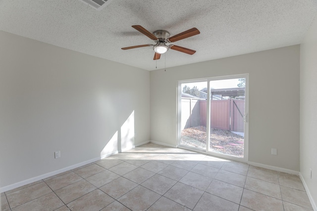 unfurnished room with ceiling fan, light tile patterned floors, and a textured ceiling