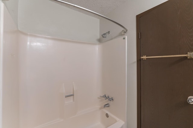 bathroom featuring a textured ceiling and shower / bathtub combination