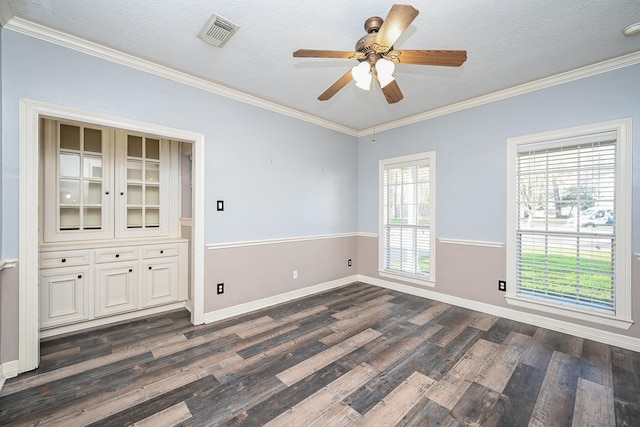 unfurnished room with crown molding, ceiling fan, dark wood-type flooring, and a textured ceiling