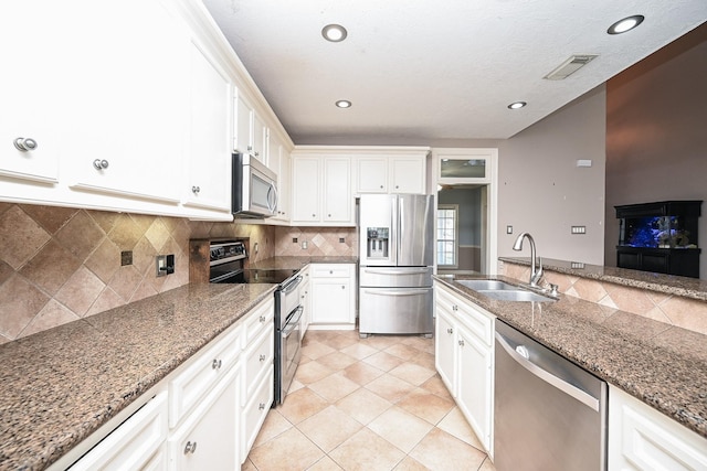 kitchen with white cabinetry, sink, stainless steel appliances, tasteful backsplash, and light tile patterned floors