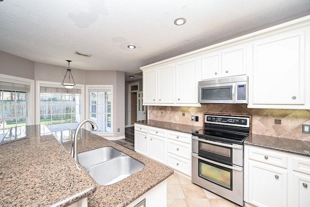 kitchen featuring appliances with stainless steel finishes, backsplash, white cabinetry, and sink