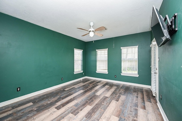 spare room featuring a textured ceiling, dark hardwood / wood-style flooring, and ceiling fan