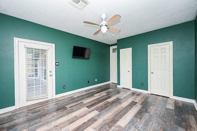 unfurnished bedroom with ceiling fan and dark hardwood / wood-style flooring